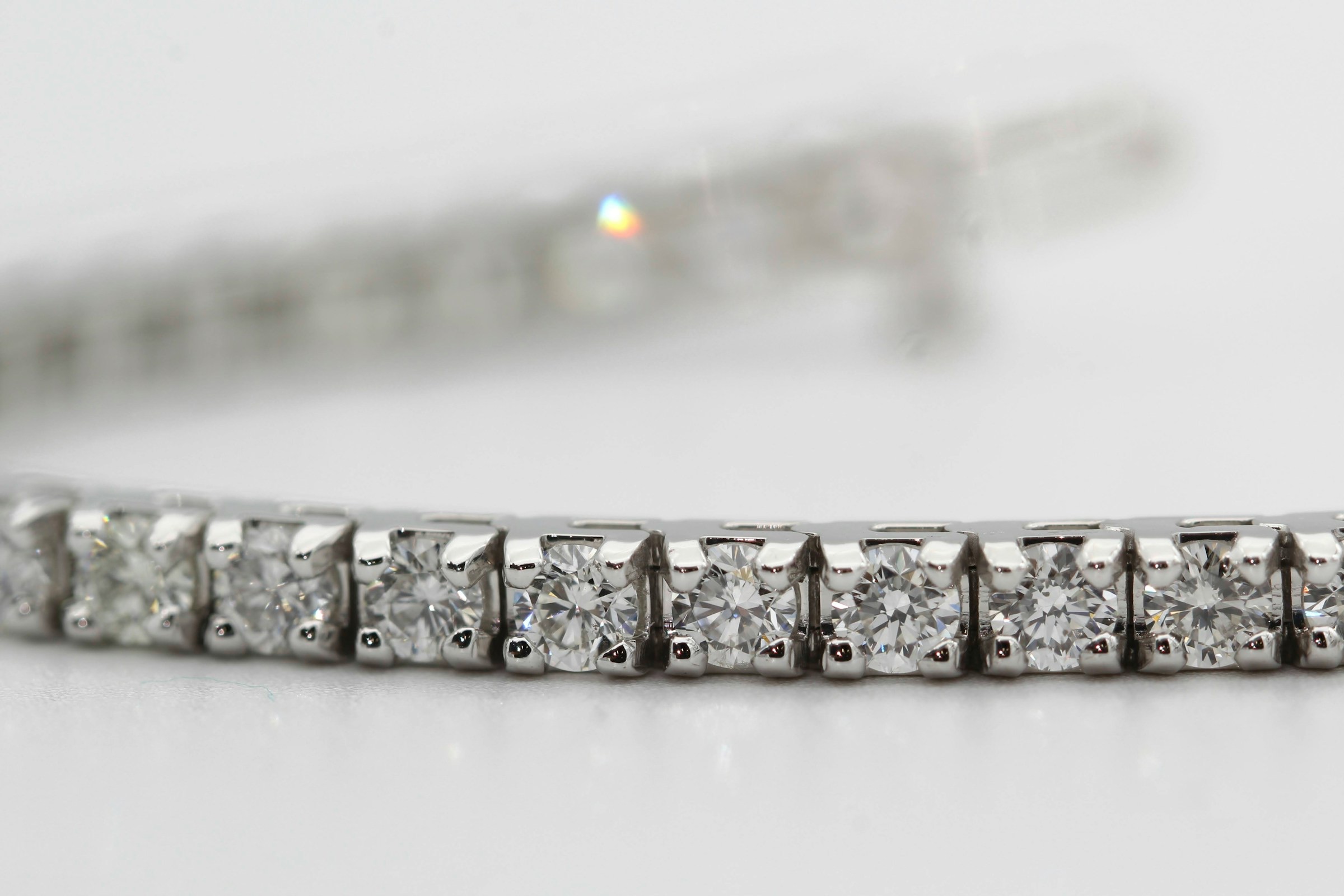 Loose diamonds on a grey ground beside a jeweler’s loupe