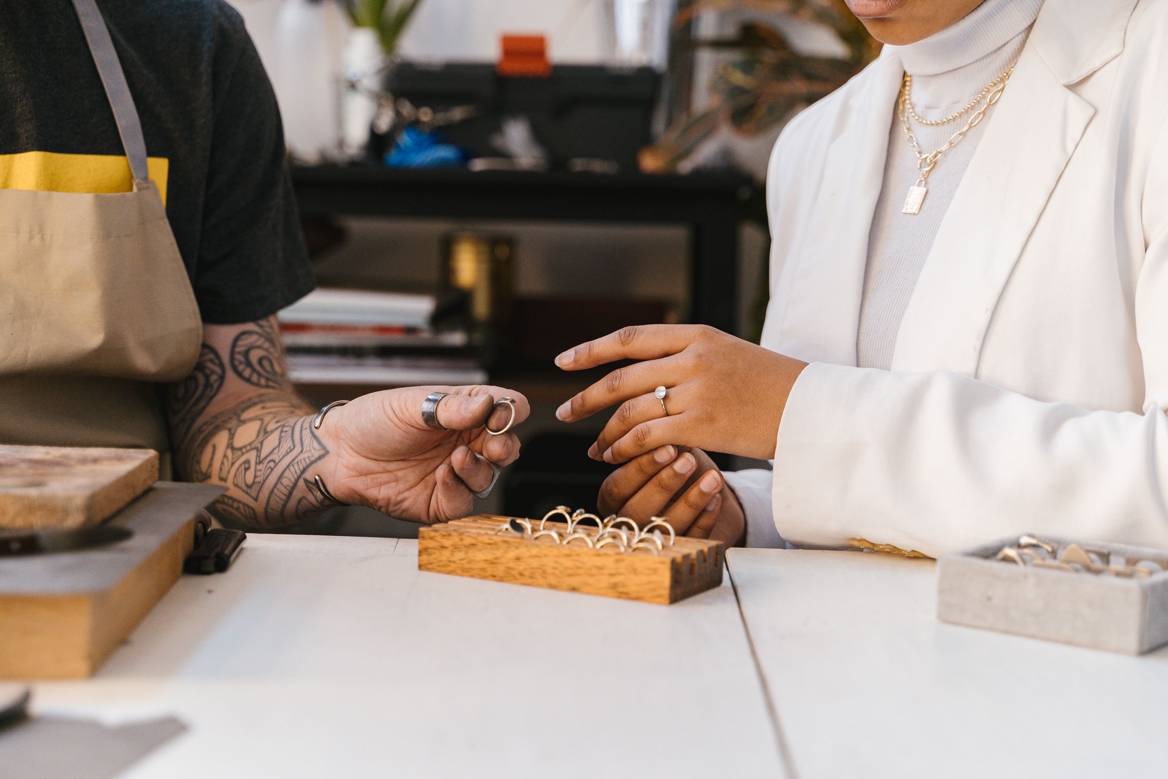 A jeweler showing loose stones to a client at a table