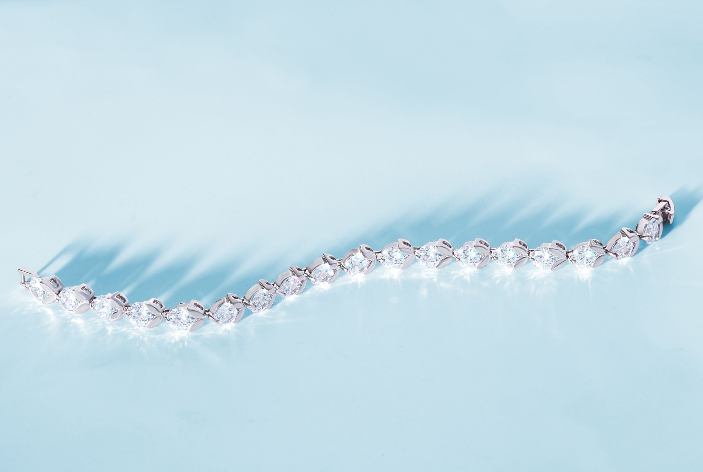 A diamond tennis bracelet on a pale grey ground